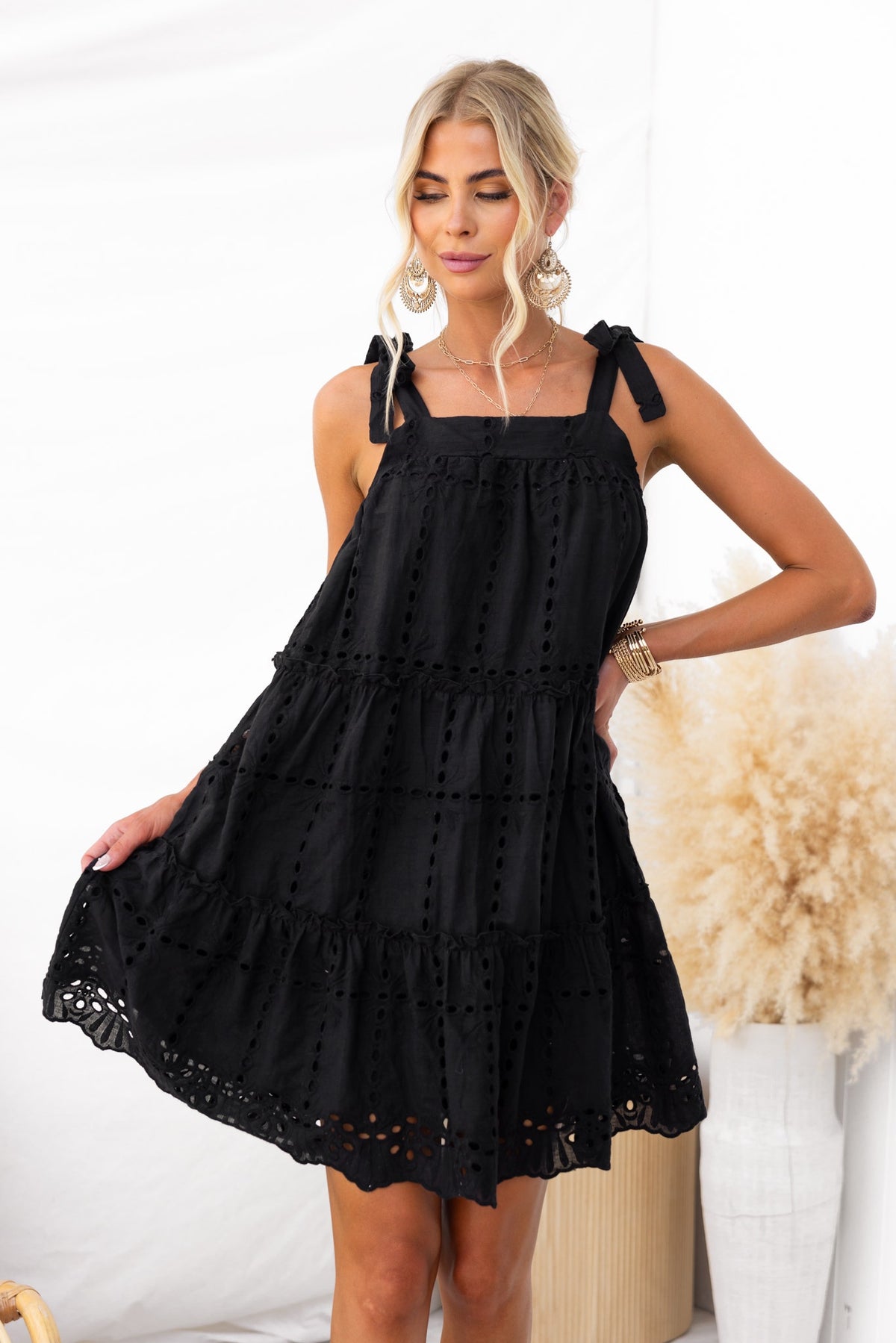 Charlene Dress: Black adjustable tie strap dress in Anglaise material, featuring a relaxed fit and lined design.