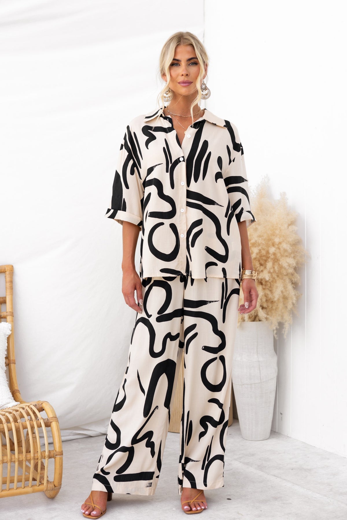 Arwen Set featuring an abstract print shirt and pants in light fabric, styled with rolled cuffs and a mid-high waist fit.