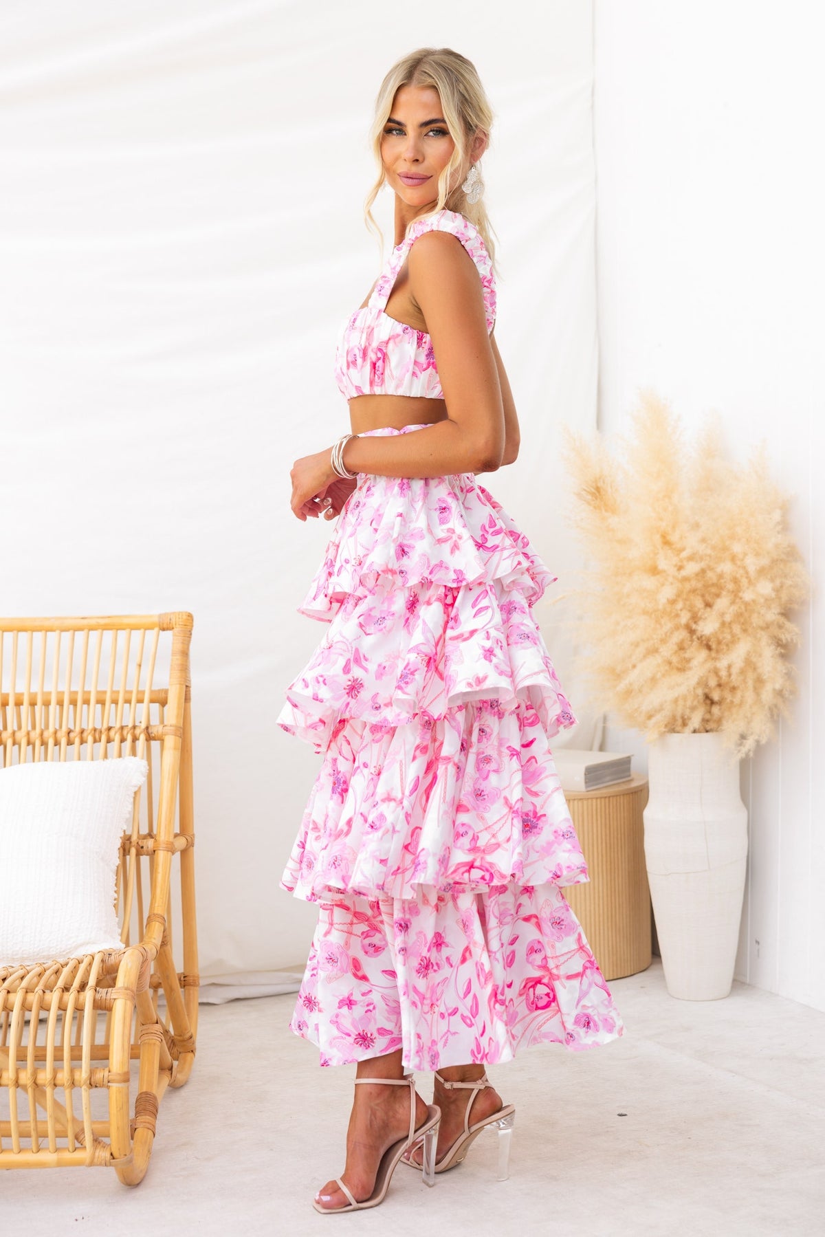 Model wearing a floral print maxi skirt and gathered top from the Illusion Set, showcasing a ruffle design.