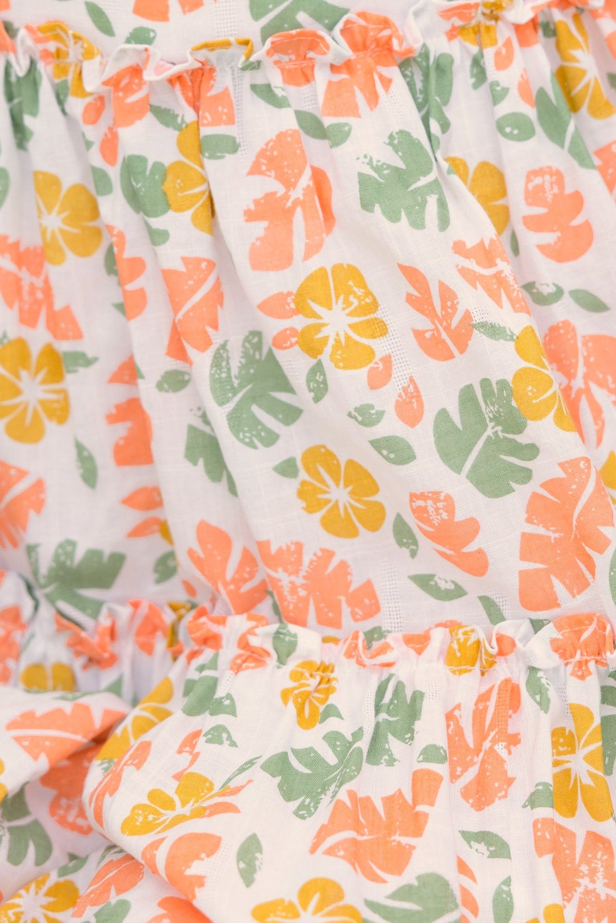 Close-up of Lorie Dress featuring vibrant floral print in pink, orange, and green on lightweight cotton fabric.