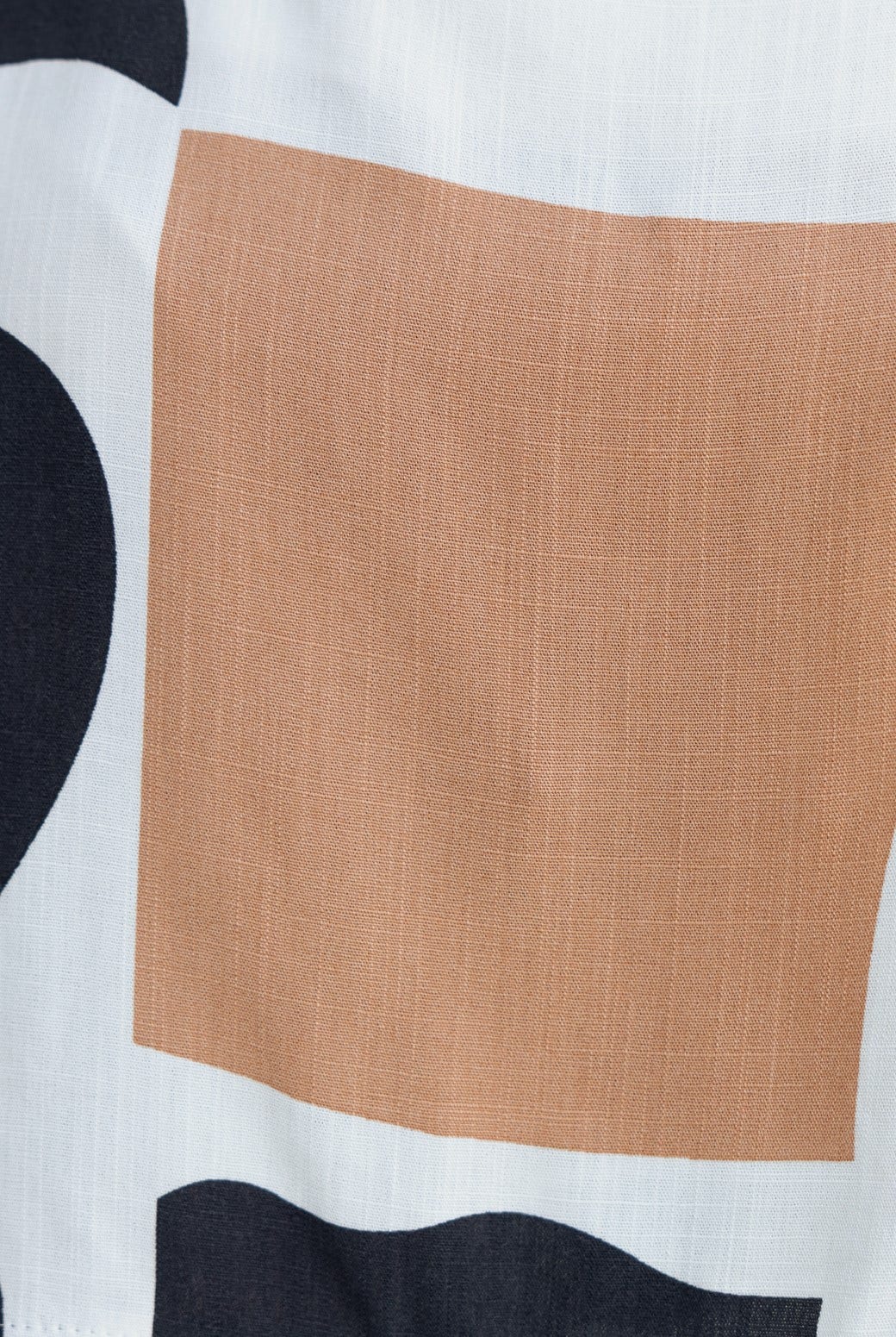 Close-up of abstract print fabric featuring earthy tones and a linen-like texture, perfect for a stylish summer outfit.