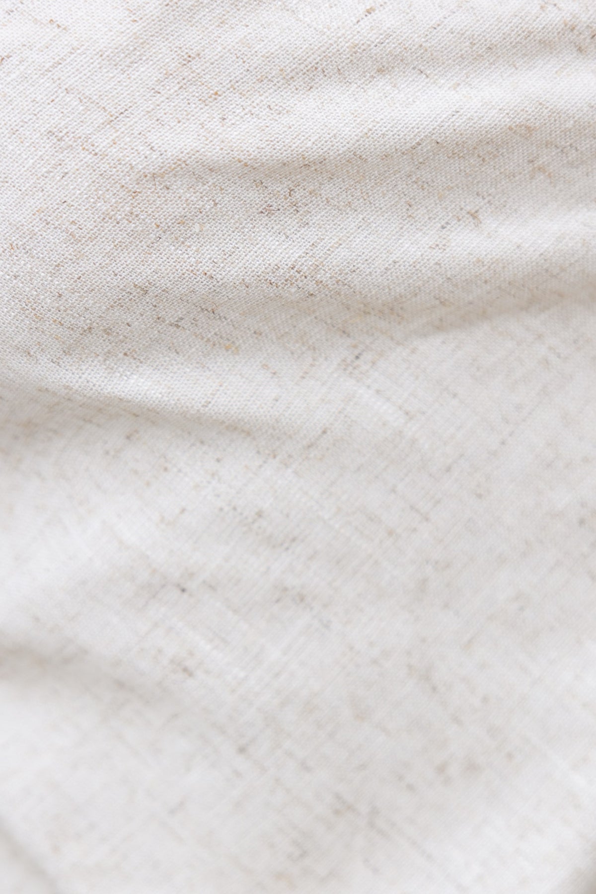 Close-up of light beige linen fabric with subtle texture, perfect for summer tops like the Mallorca Top.