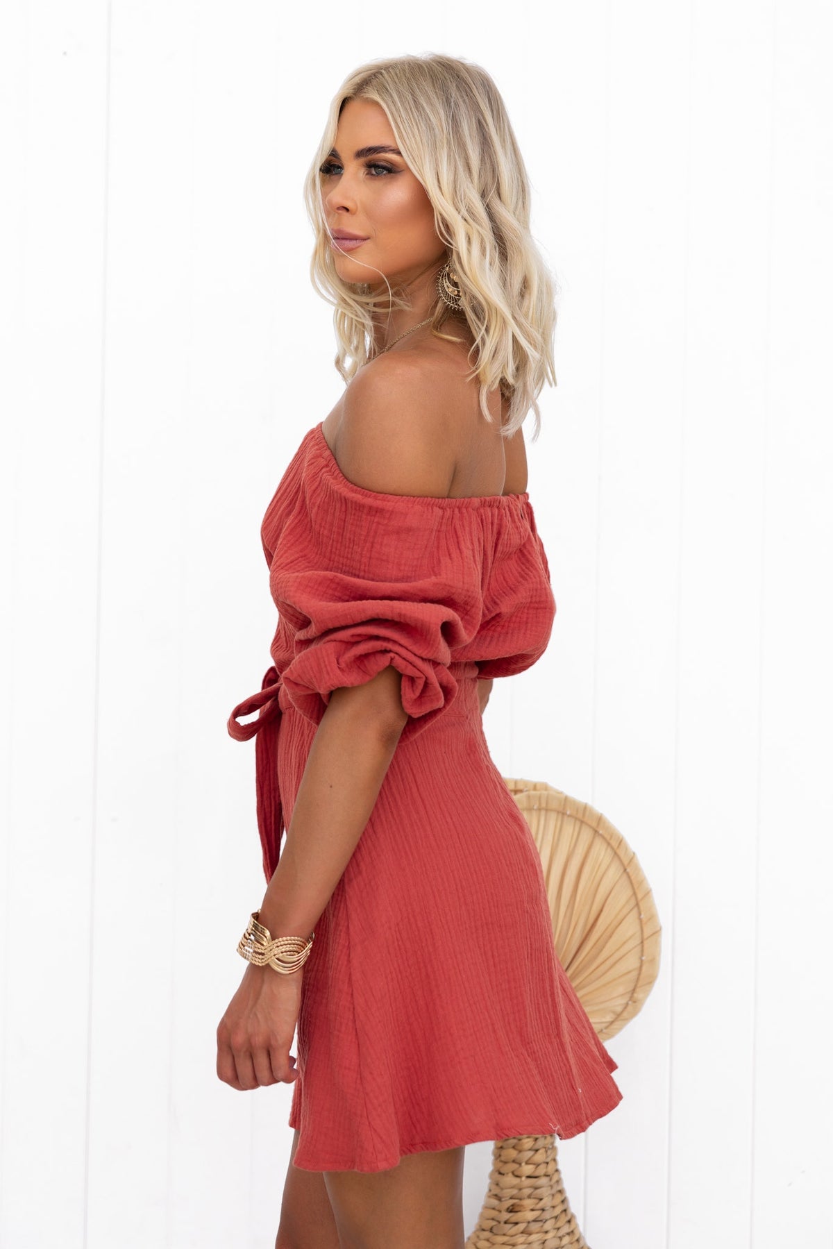 Mykel Dress featuring off-shoulder neckline, cut-out waist, and textured material in rust color.