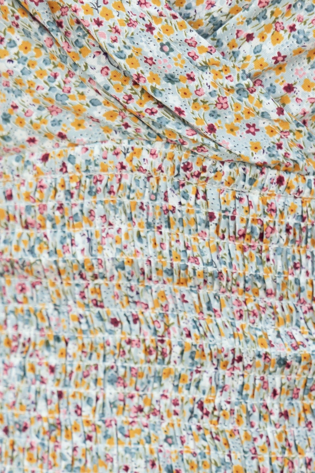 Close-up of floral pattern on the Cavani Dress, featuring delicate colors and elasticated design.