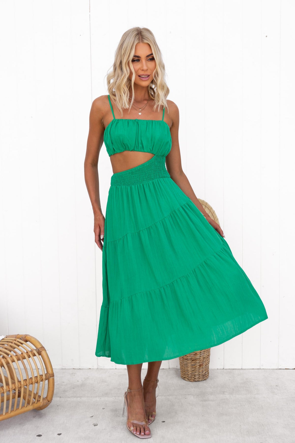 Panama Midi Dress in vibrant green with adjustable straps and cut-out waist, styled with natural accessories.