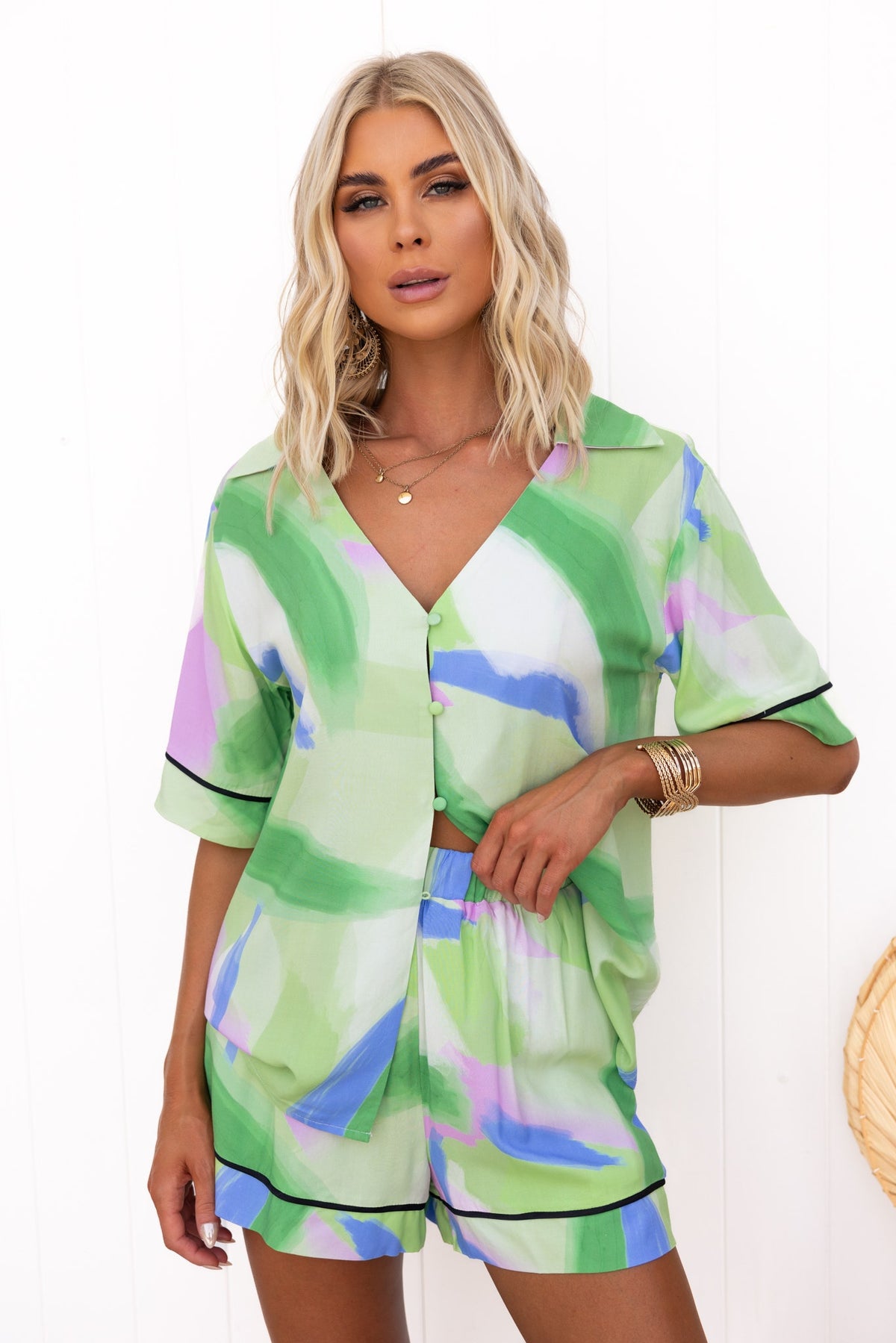 Model wearing a green and purple print Focus Shirt with a relaxed fit, featuring a button-up front and short sleeves.