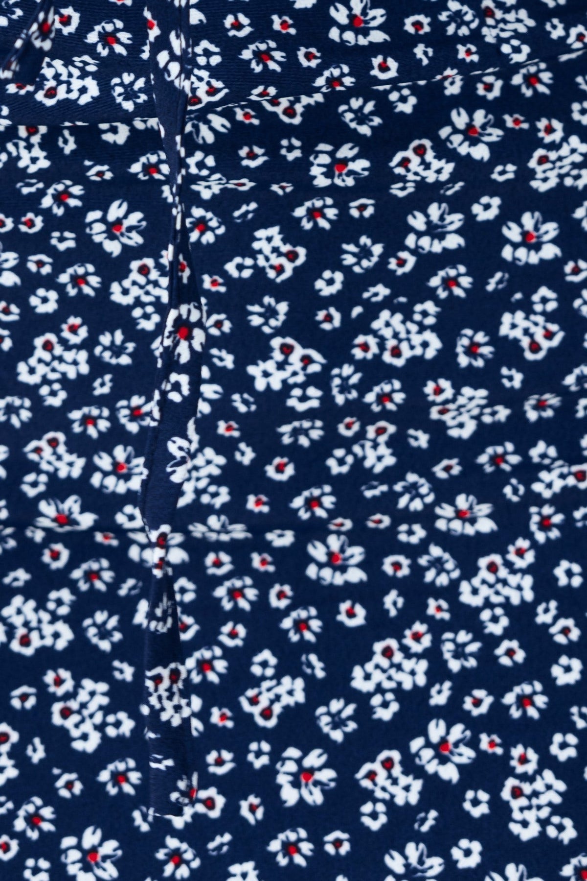 Close-up of navy fabric with white and red floral print, featuring a delicate pattern for the Arquette Dress.