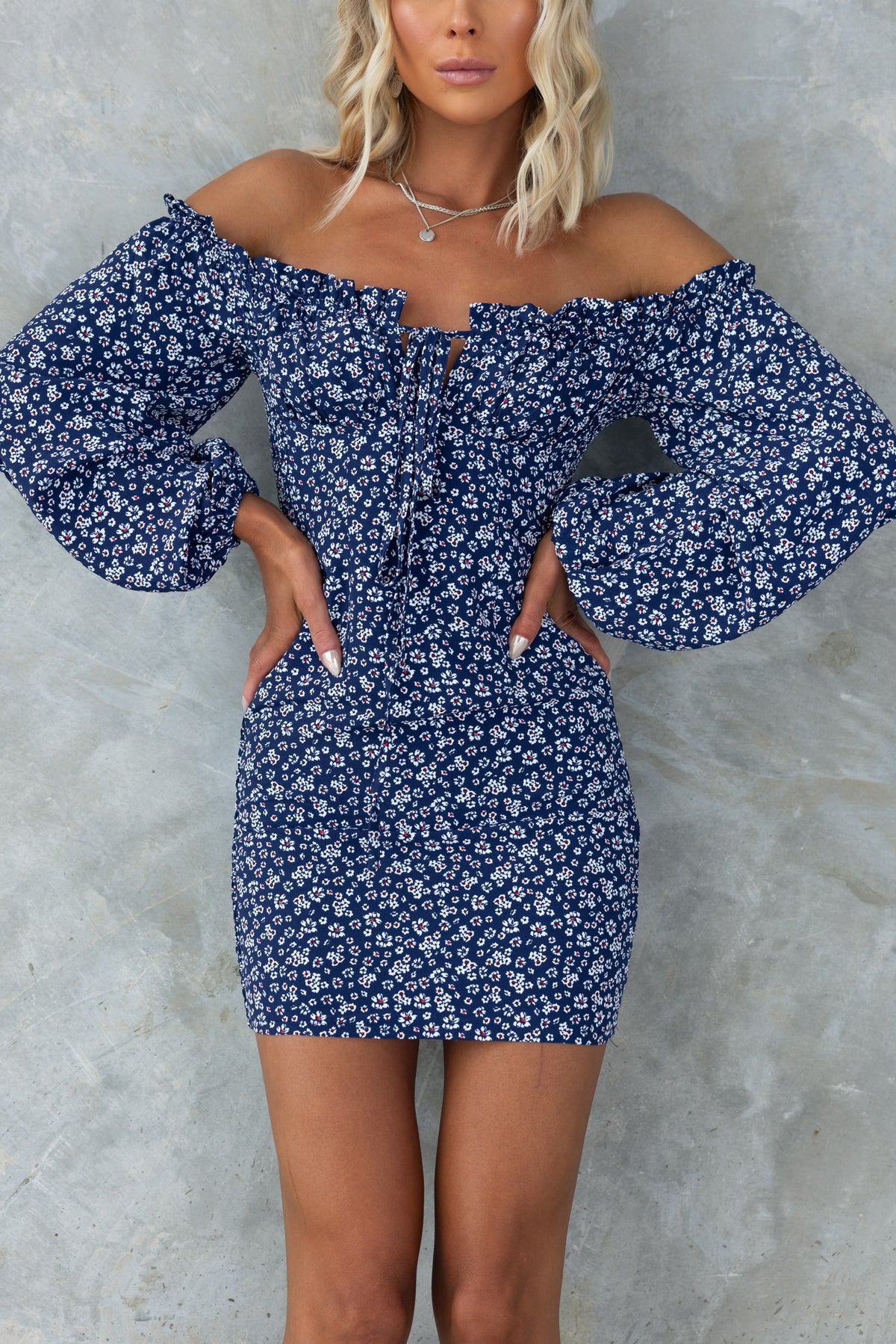 Navy Arquette dress featuring off-shoulder neckline, tie detail, and floral print, perfect for a stylish summer look.