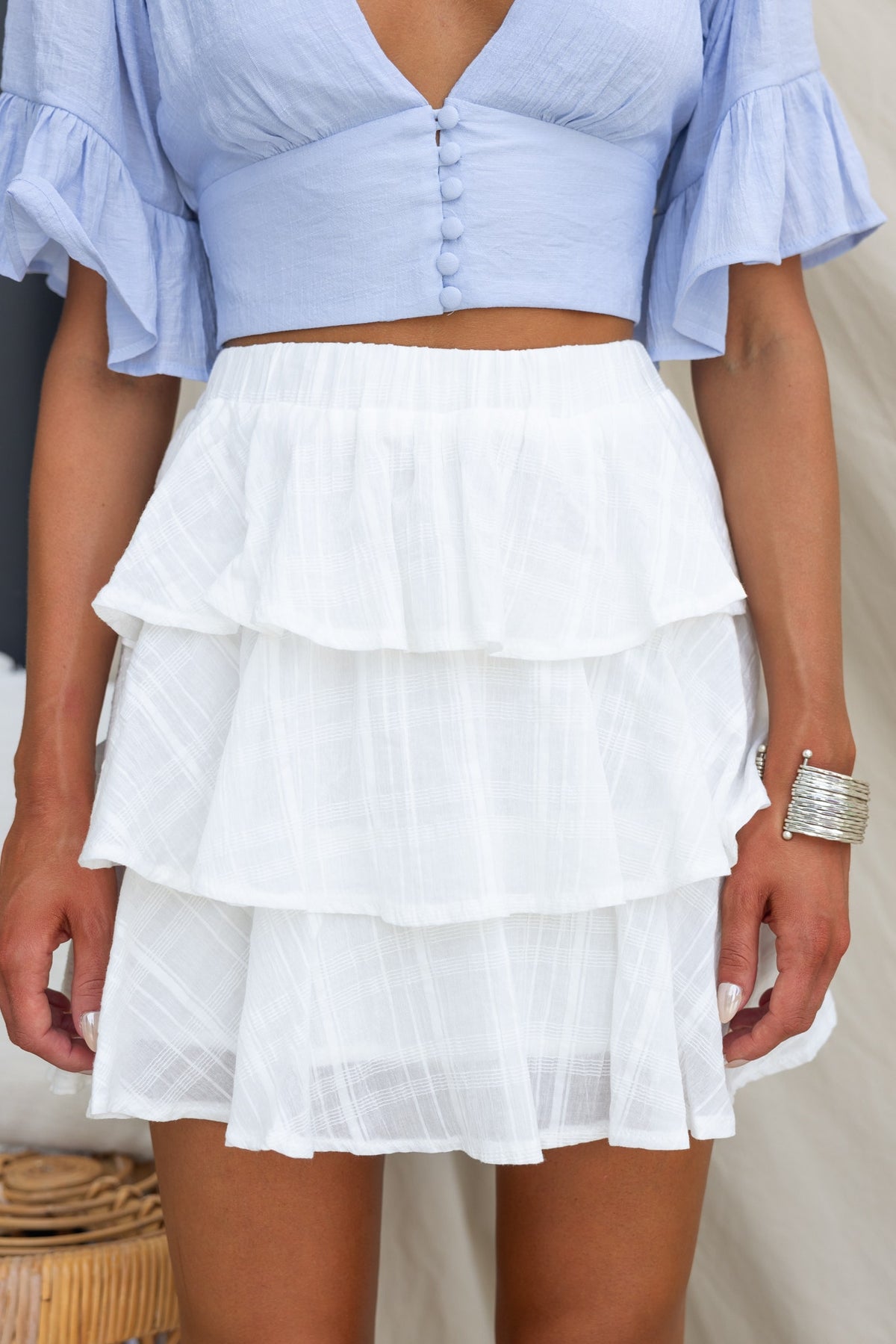 Madoni Skirt featuring a mid-high waist, textured material, and layered design, styled with a light blue top.