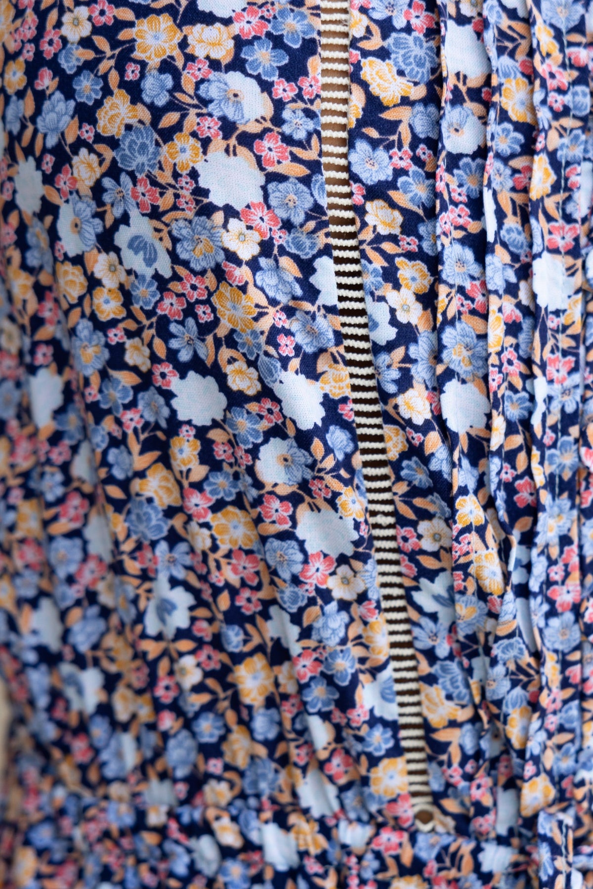 Close-up of Samia Jumpsuit fabric featuring floral patterns in blue, pink, and yellow with elastic waistband.