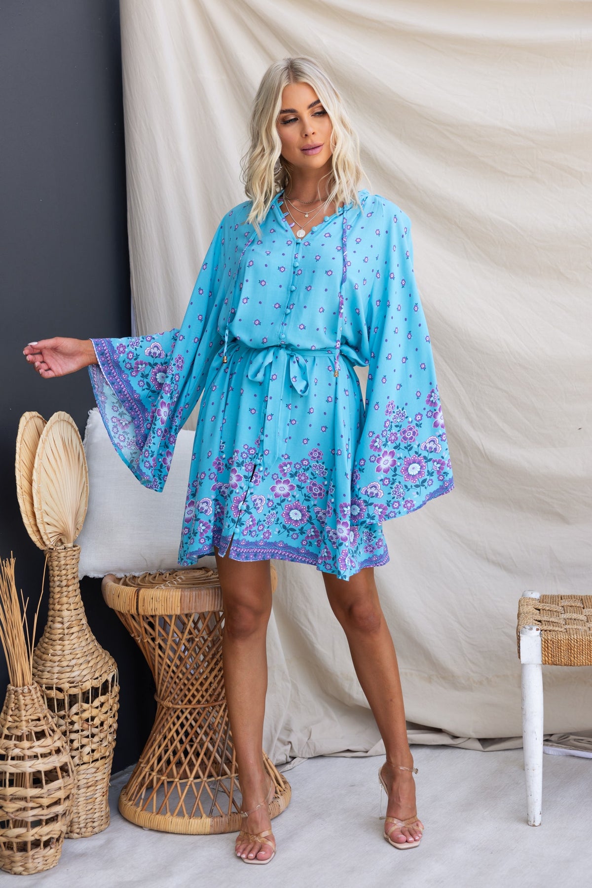 Nolla Dress in blue with tie detail, wide sleeves, featuring floral patterns, perfect for casual summer wear.