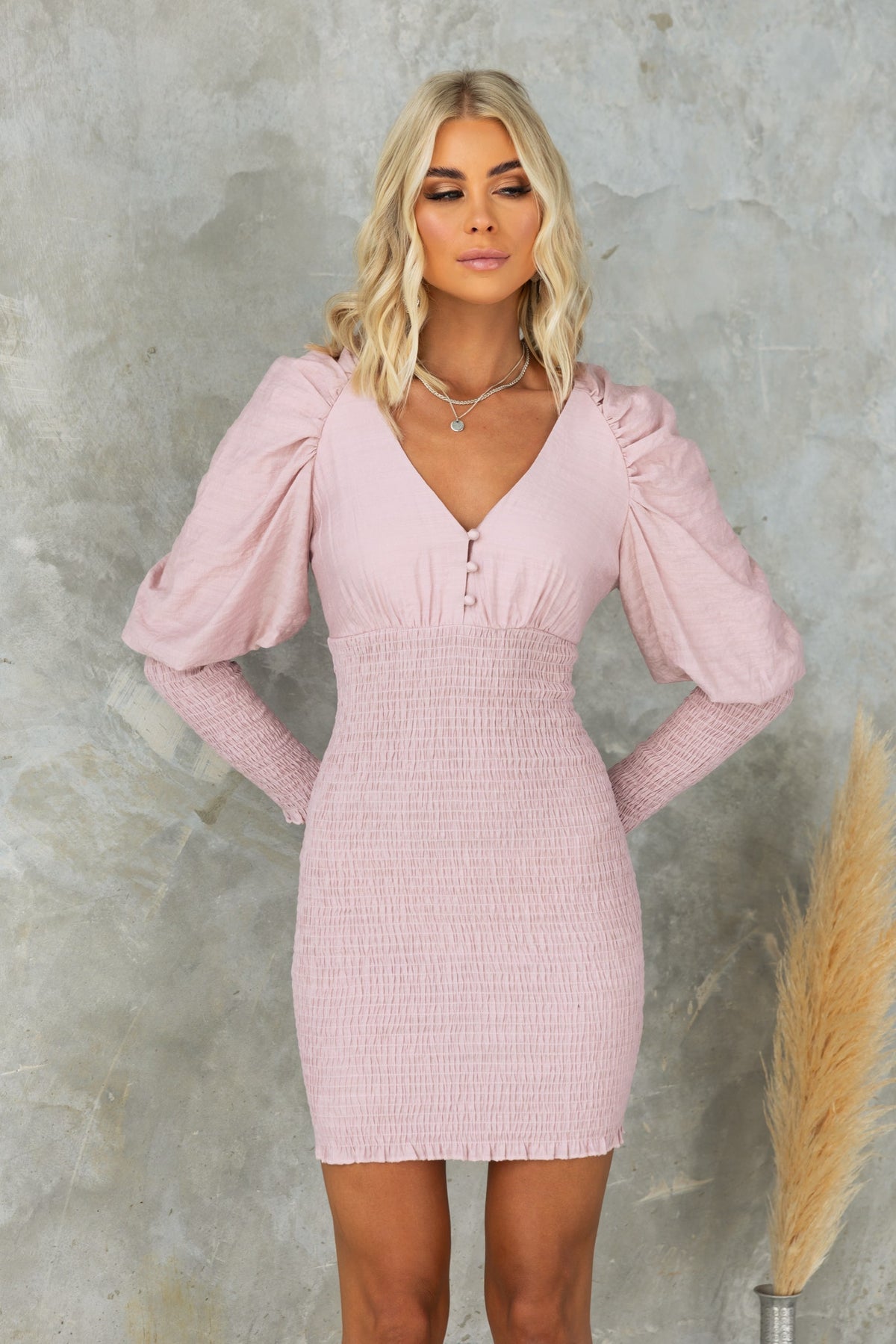 Stylish pink dress with puff sleeves, button-up front, and fitted body for a chic look.