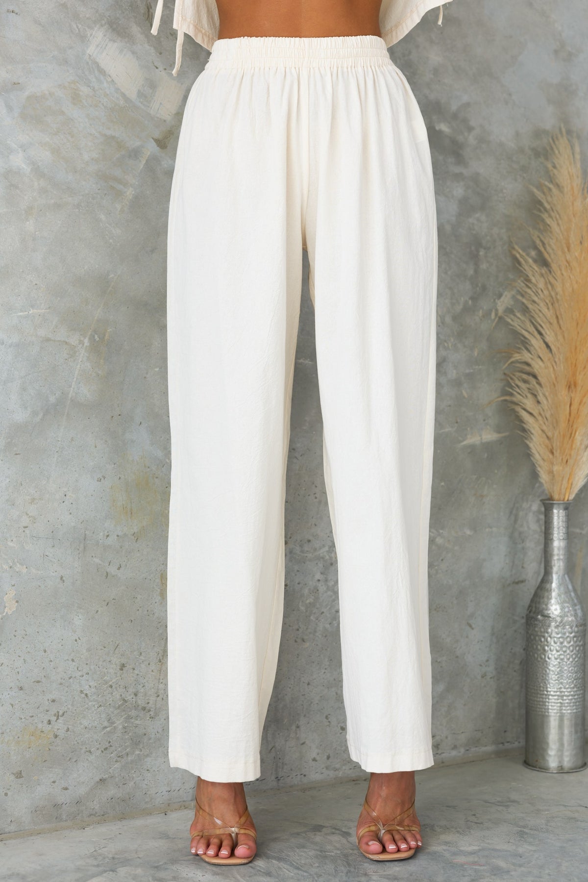 Vesper Pants in soft beige with mid-high waist and elastic waistband, perfect for casual wear and comfort.