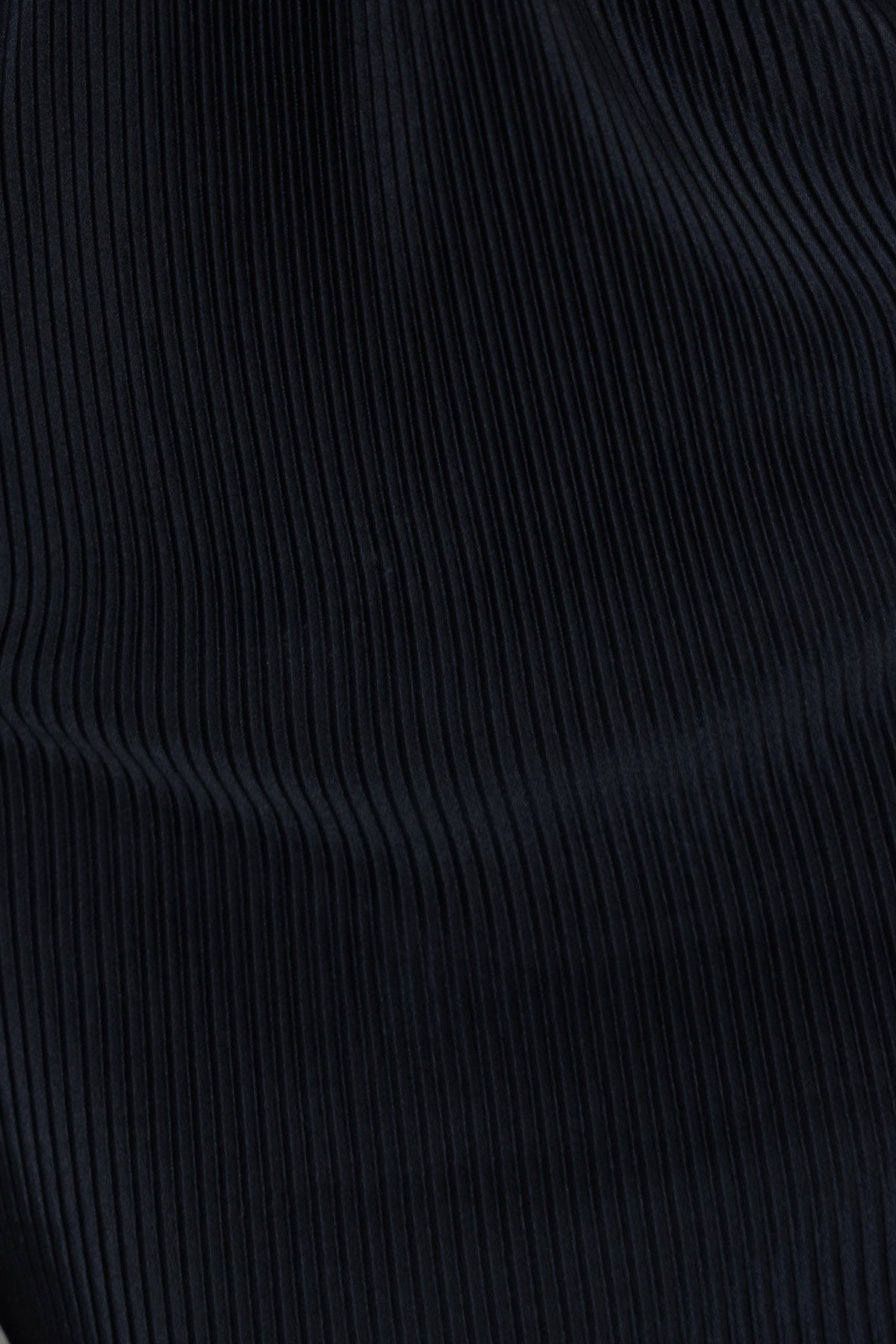 Black accordion pleat material of a midi dress with slight stretch and elegant texture.