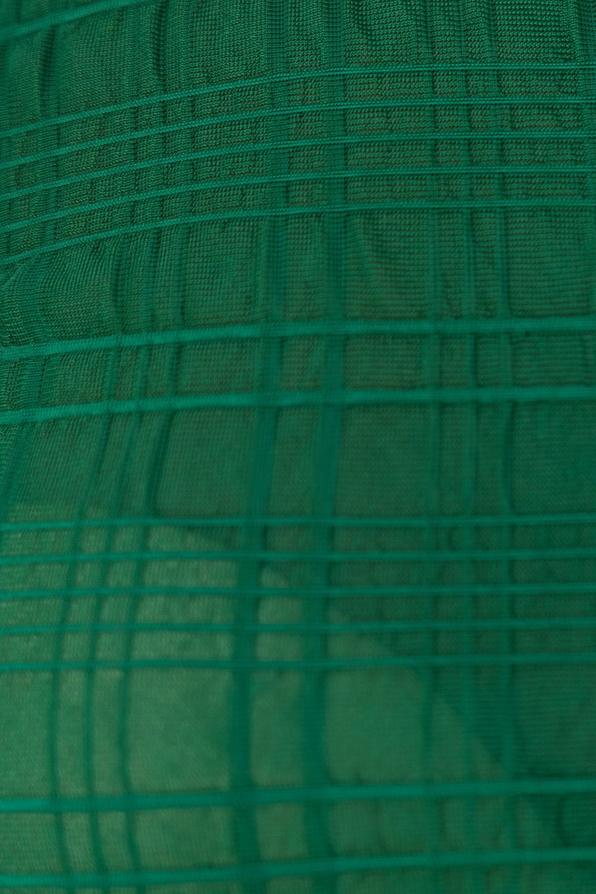 Close-up of textured green mesh fabric showcasing a grid pattern, ideal for stylish bodysuit designs.