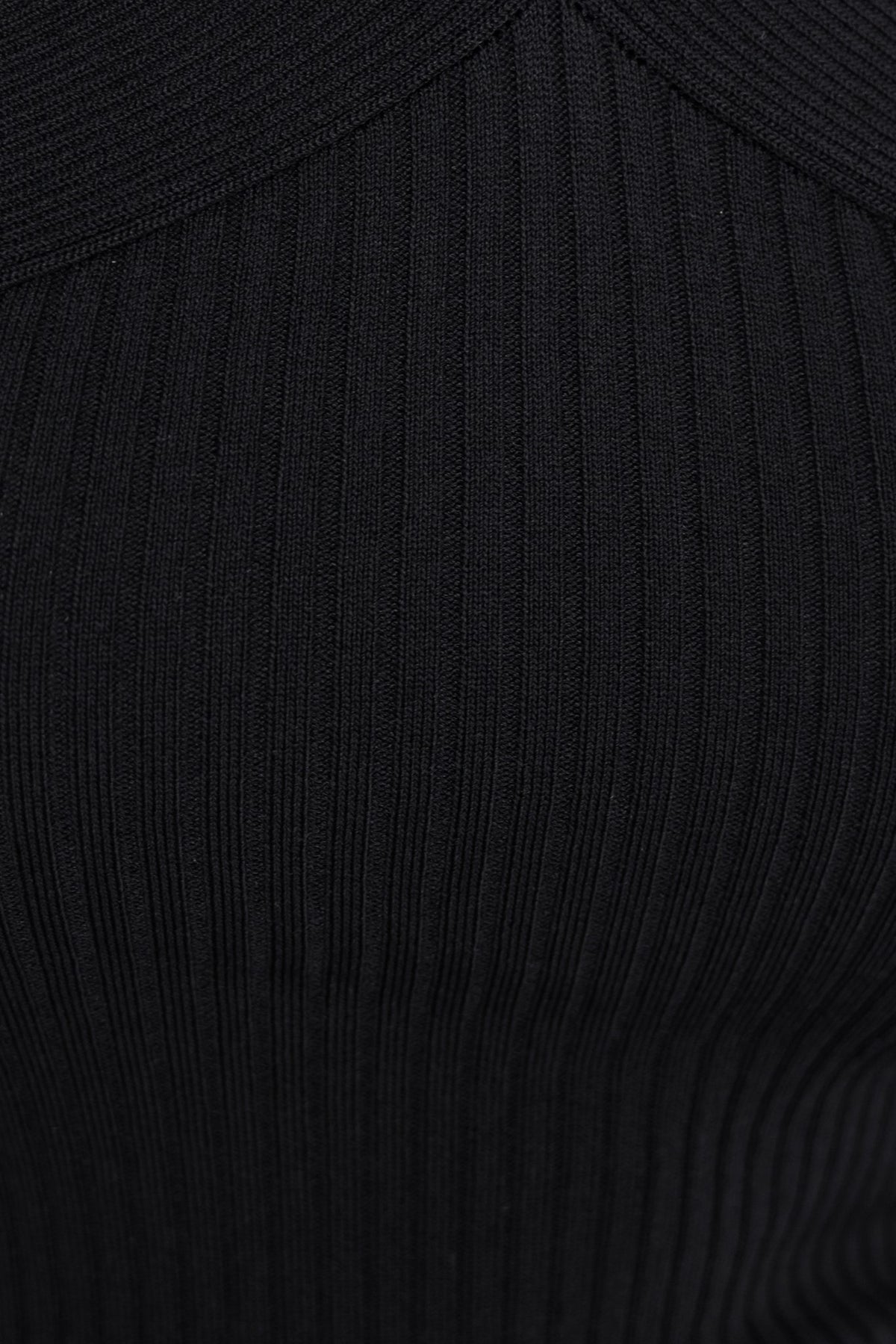 Close-up of a black ribbed knit halter top showcasing ring detail and textured fabric.