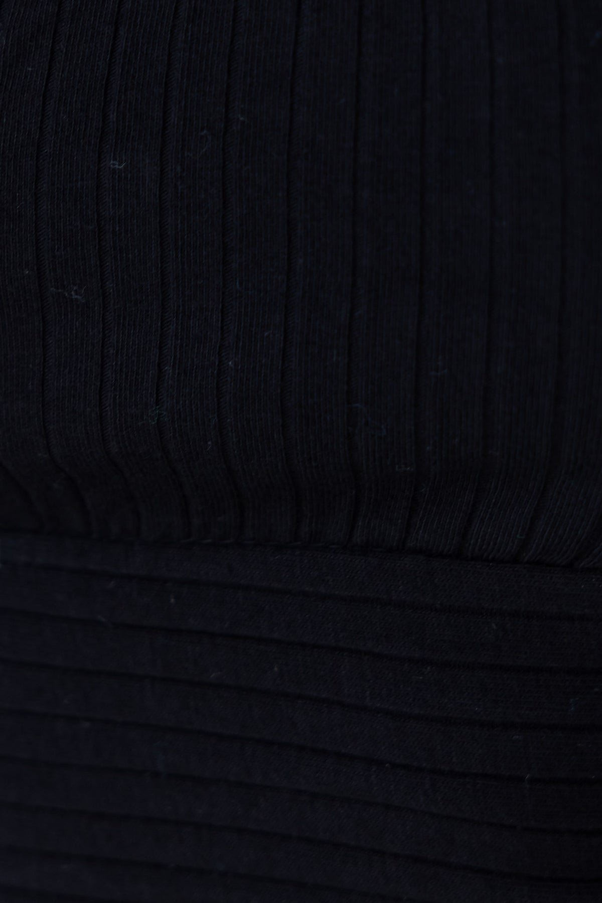 Close-up of ribbed black top highlighting stretchy material and unique texture, perfect for a standard fit.