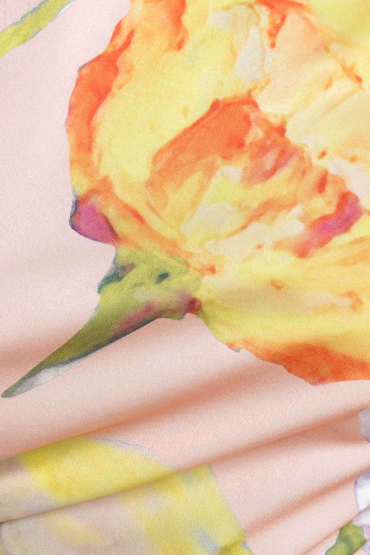 Close-up of floral print fabric in vibrant yellow and orange hues, ideal for a stylish midi dress.