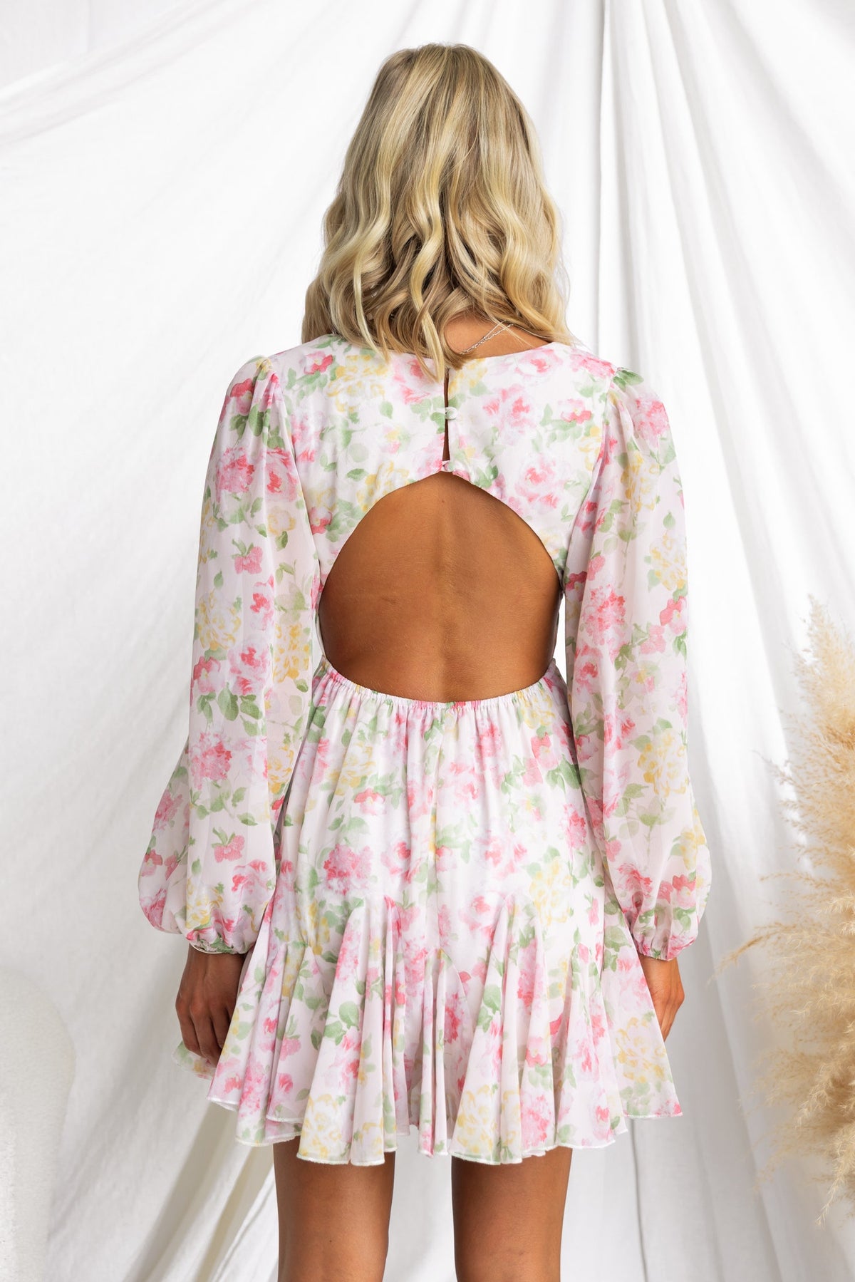 Back view of a floral Kersty dress with a cutout and puff sleeves, showcasing a flared skirt design.