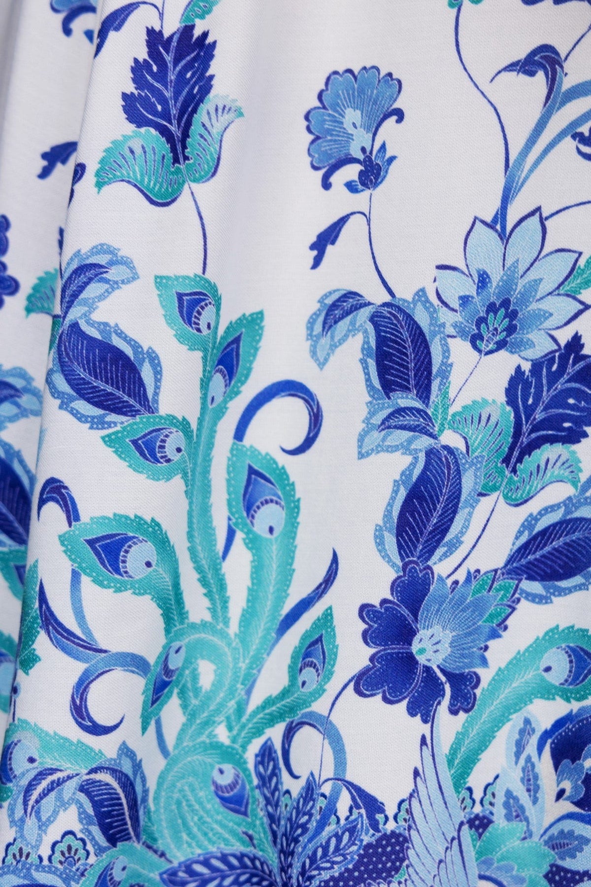Close-up of a floral pattern in blue and turquoise on the Lenika Dress fabric, showcasing intricate designs.