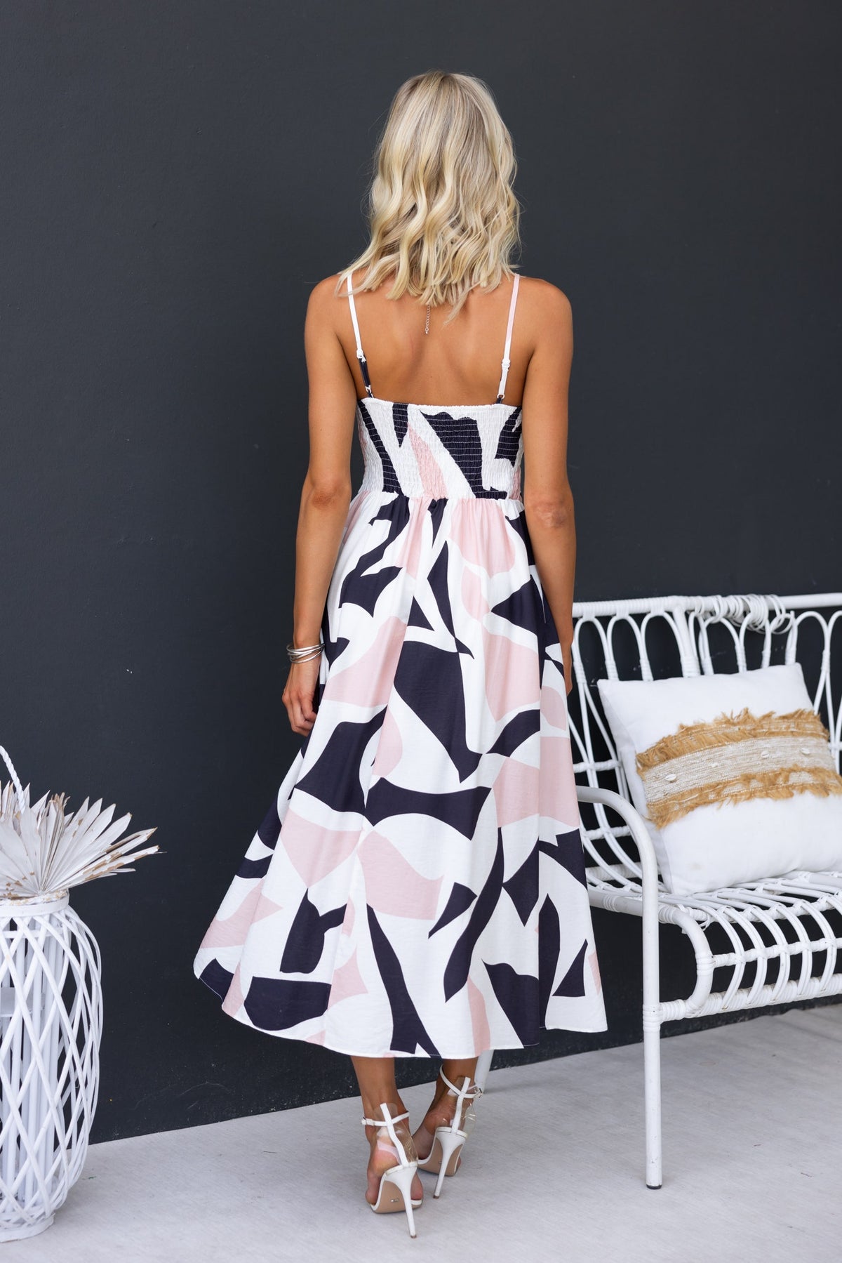 Back view of Otherside Midi Dress, featuring adjustable straps, tie bust, and a stylish abstract print.