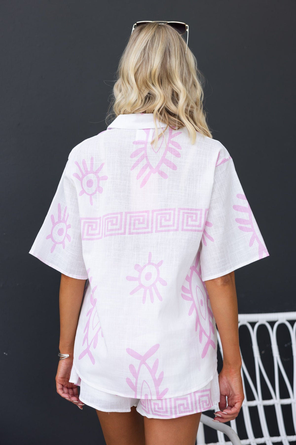 Back view of Tamba Set shirt with pink sun print, paired with non-stretch shorts, ideal for warm weather styling.