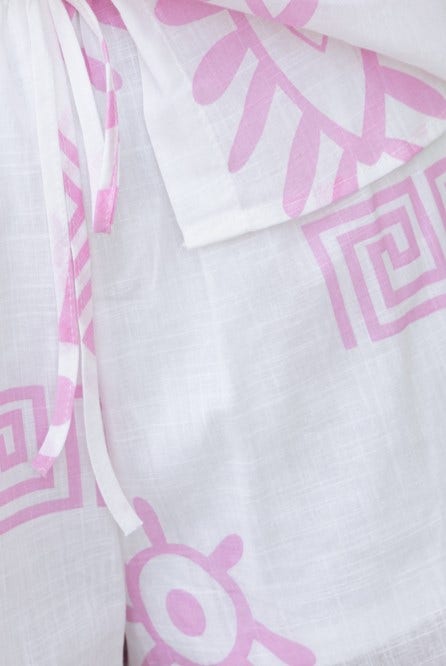Close-up of Tamba Set featuring pink print design on white fabric with tie detail and elastic waistband.