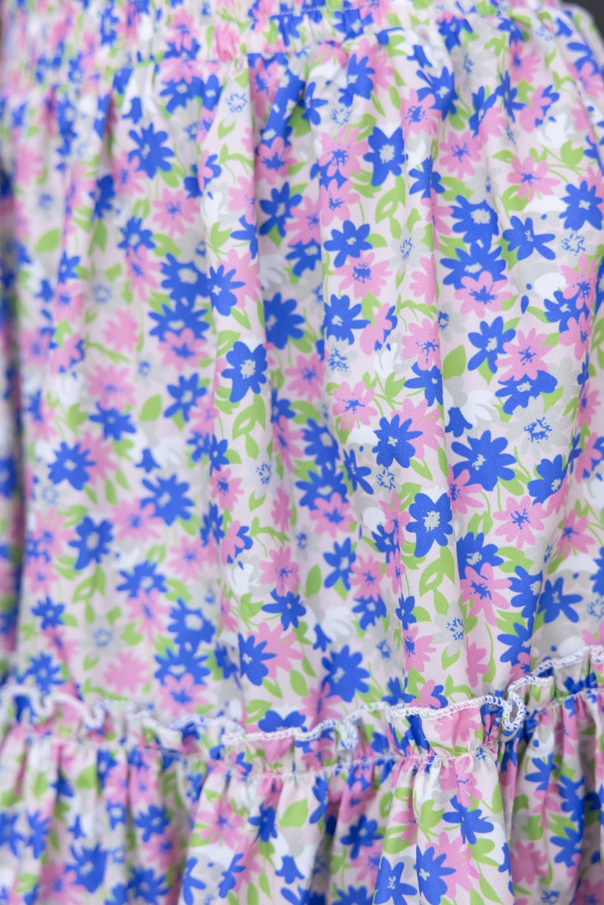 Floral pattern close-up of the Syana Skirt, featuring vibrant pink and blue flowers on a light background.