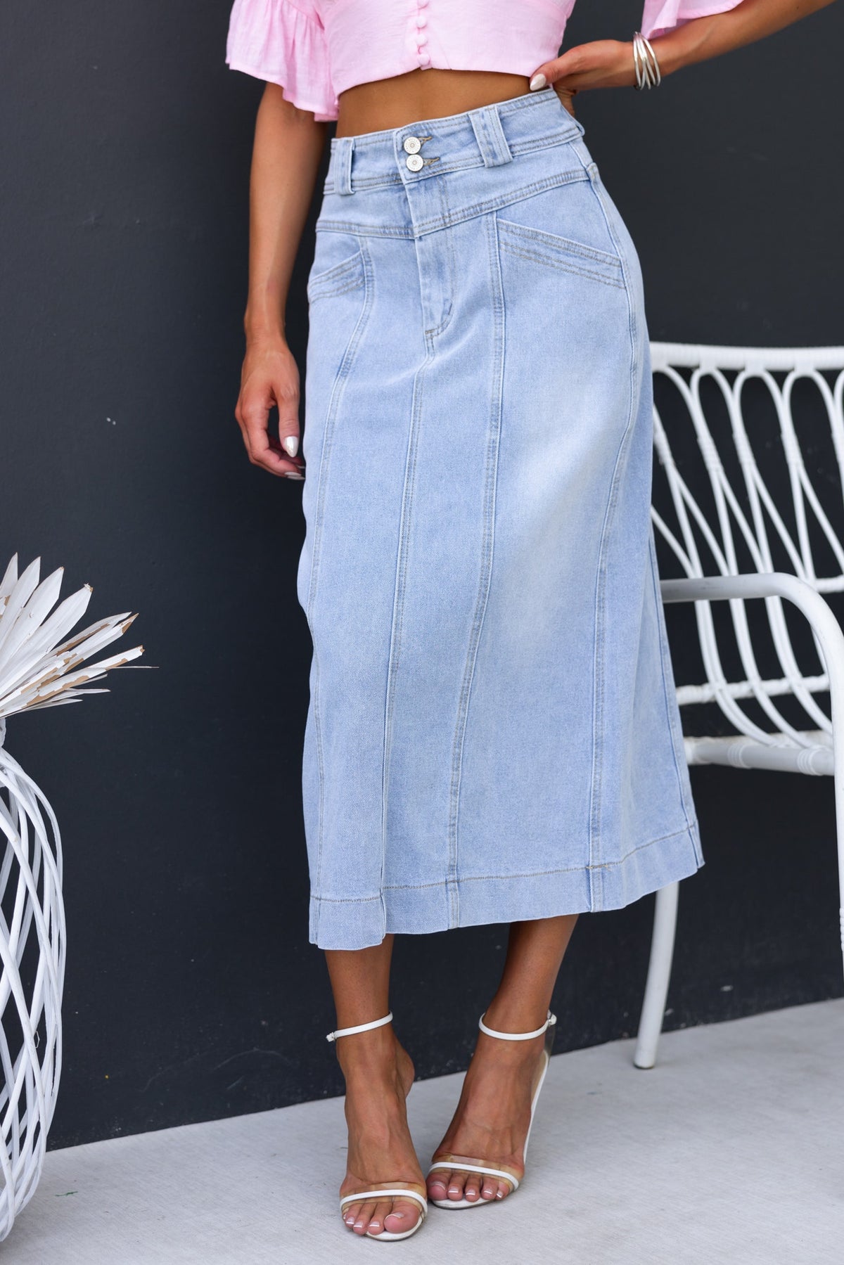 Azra Denim Midi Skirt featuring mid-high waist, front pockets, and stretch material for a stylish look.