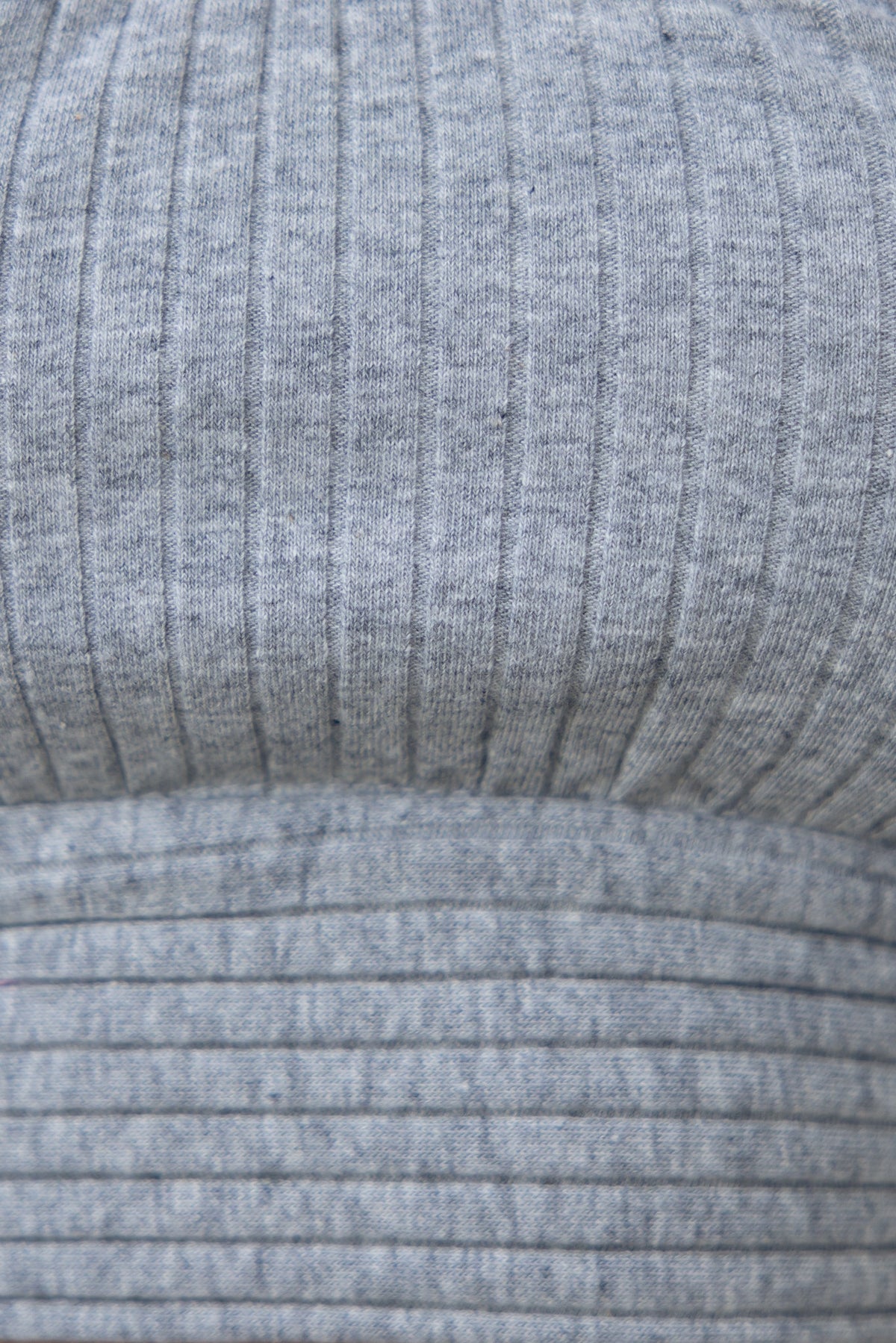 Close-up of ribbed gray top made from stretchy rayon and elastane, showcasing its fabric texture and design.