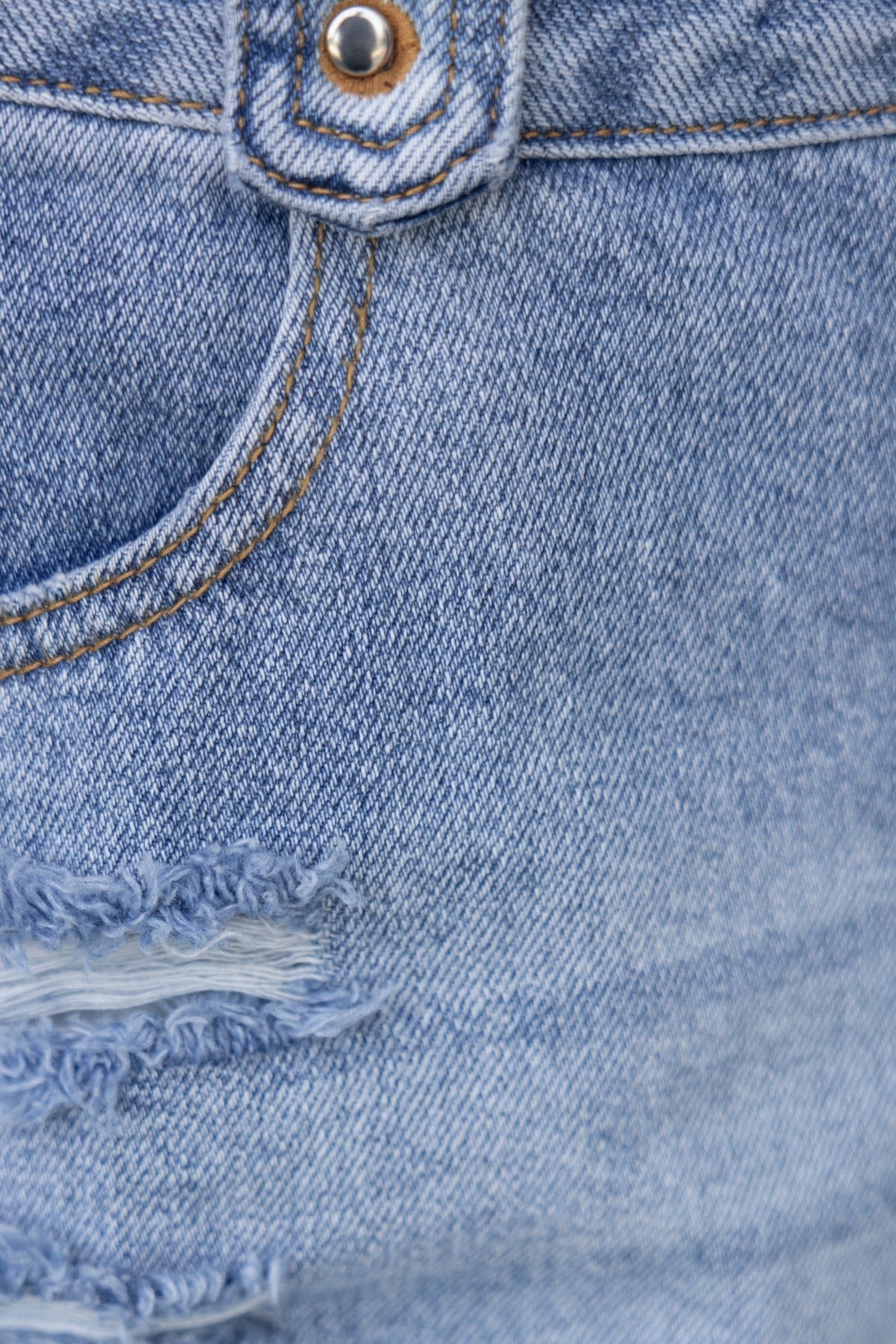 Close-up of distressed denim fabric showcasing pocket and stitching details of the Kaylie Jeans.