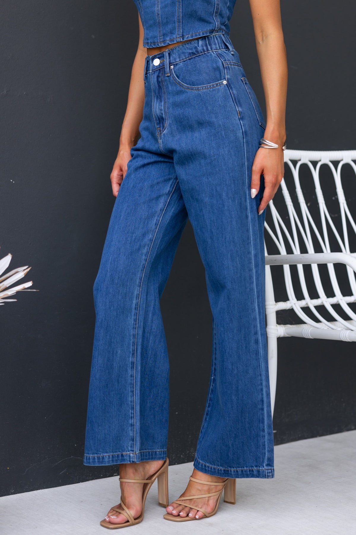 Sierra Jeans featuring wide-leg fit, mid-high waist, and denim material styled with a trendy top and heels.
