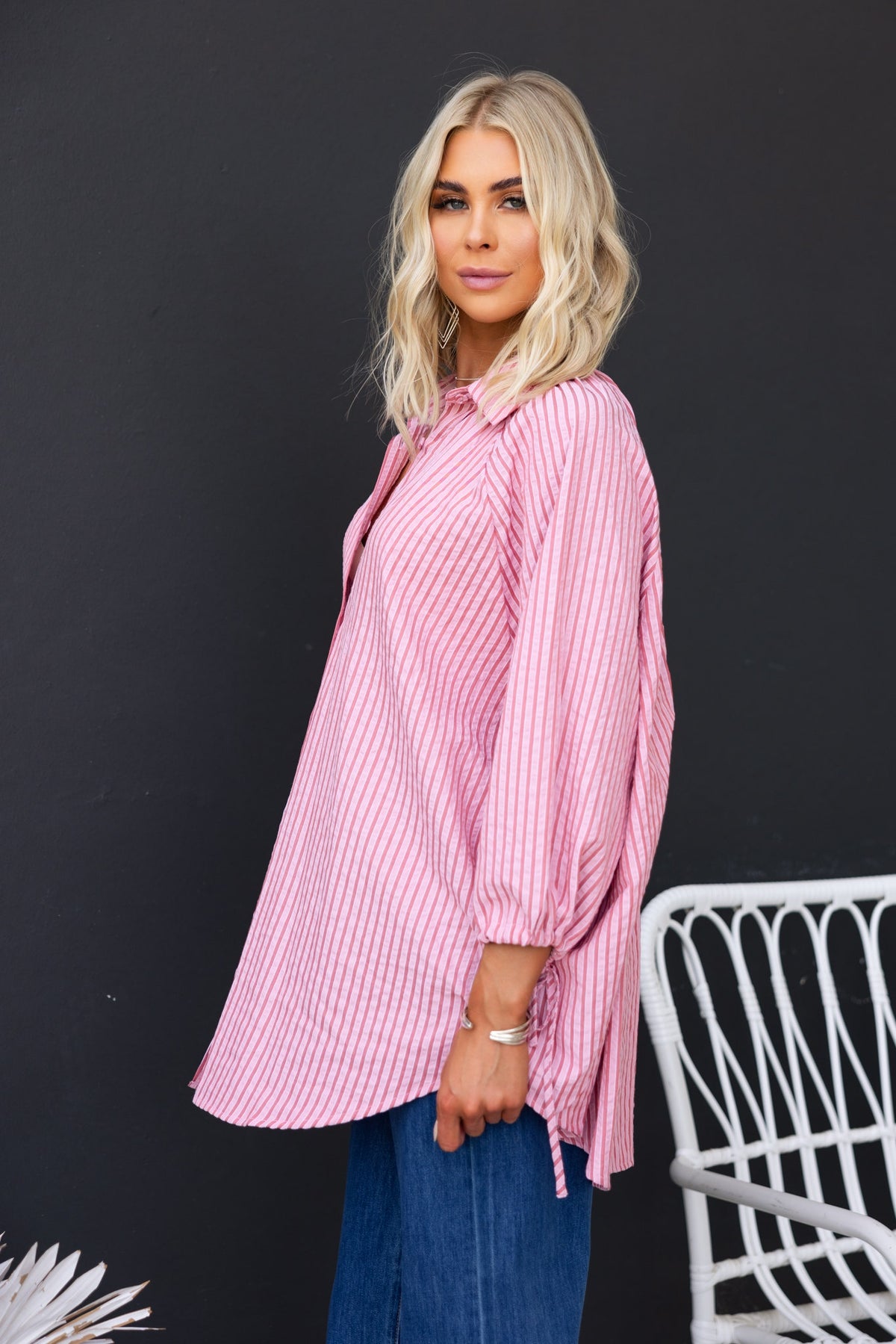 Woman wearing a pink striped Sorbet Shirt featuring a collar and oversized fit with tie details at the sleeves.