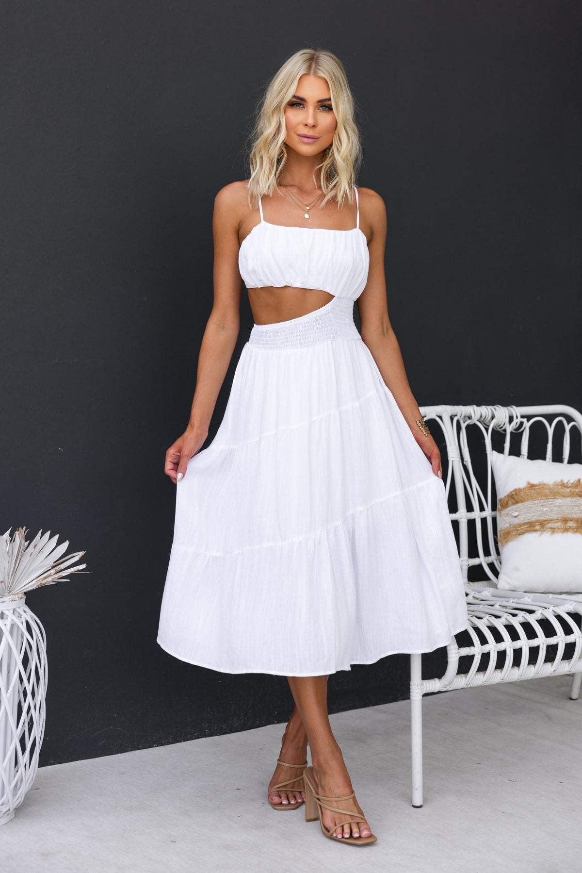 Woman wearing a stylish white Panama Midi Dress with adjustable straps and a cut-out waist design.