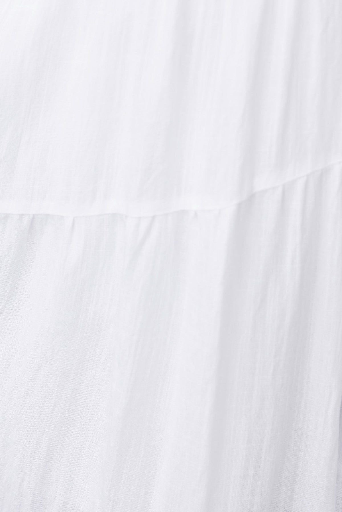 Close-up of lightweight white fabric showcasing soft texture and airy layers for the Panama Midi Dress.