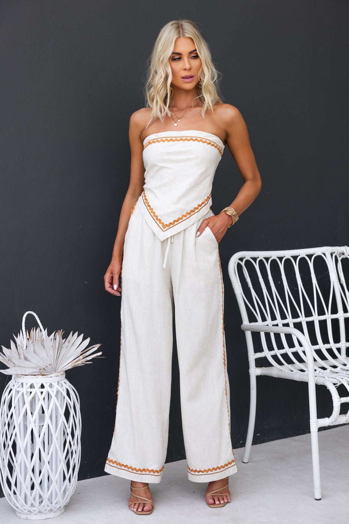 Model wearing a strapless Mallorca top with a linen feel, styled with wide-leg pants and a chic boho vibe.