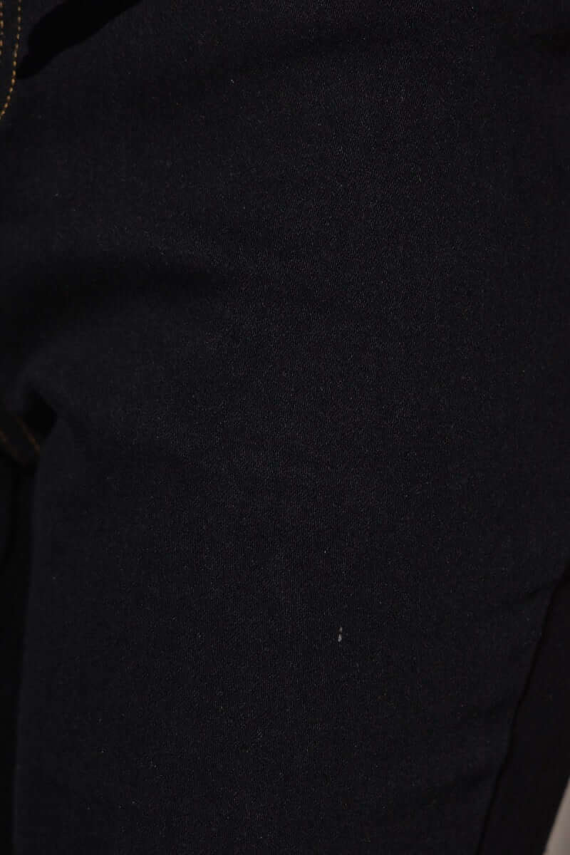 Close-up of the Xenia Denim Jumpsuit fabric in black, showcasing texture and detail of the denim material.