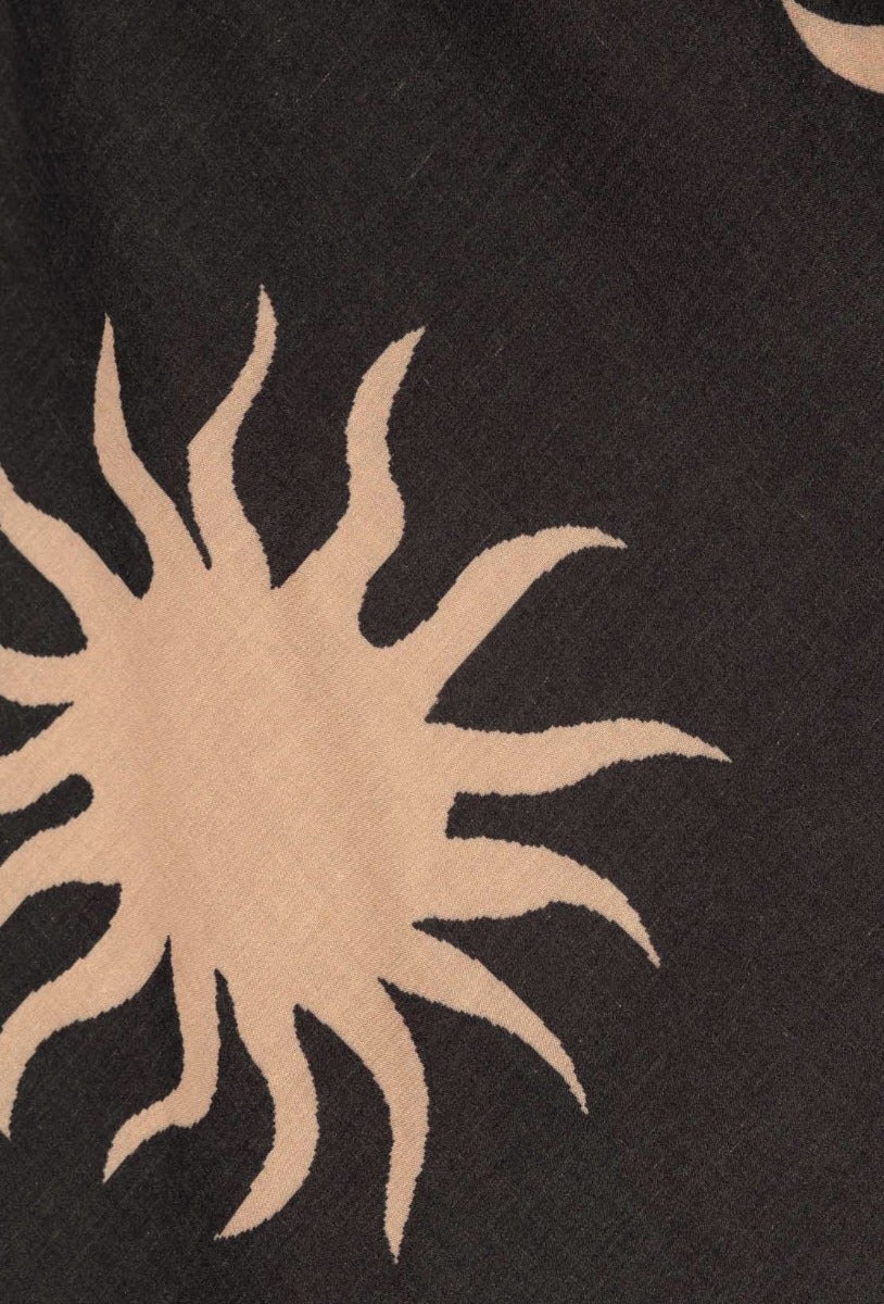 Faded black fabric featuring a stylish sun print in tan, ideal for a trendy summer dress.