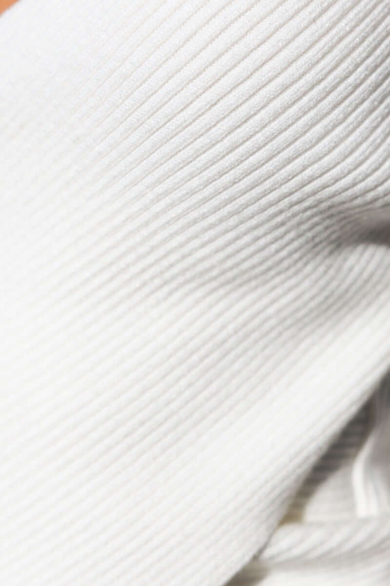 Close-up view of Inala Top's ribbed knit fabric in soft white, showcasing its texture and stretch.