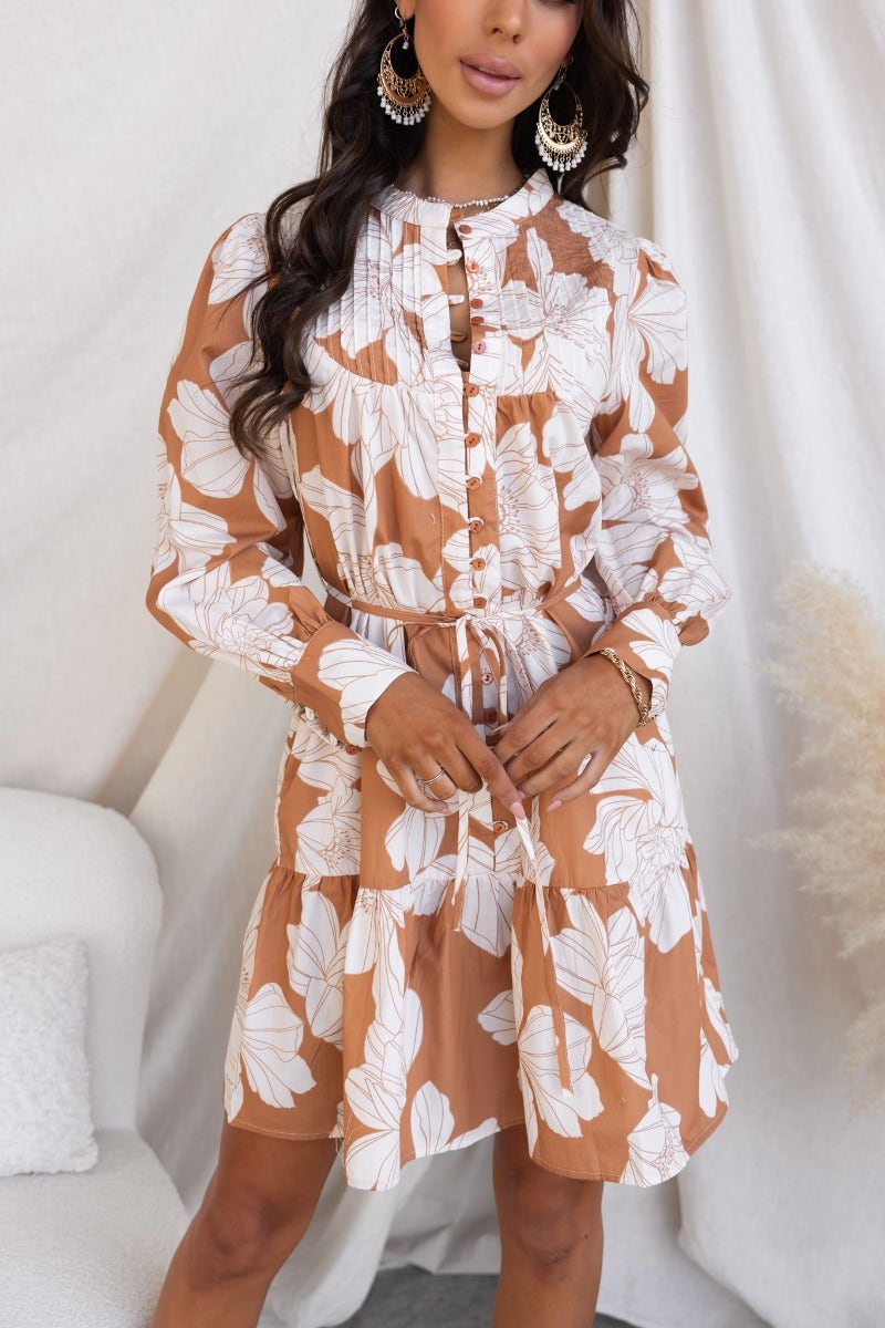 Mellow dress featuring a floral print, round neckline, and button-up front with a removable tie.