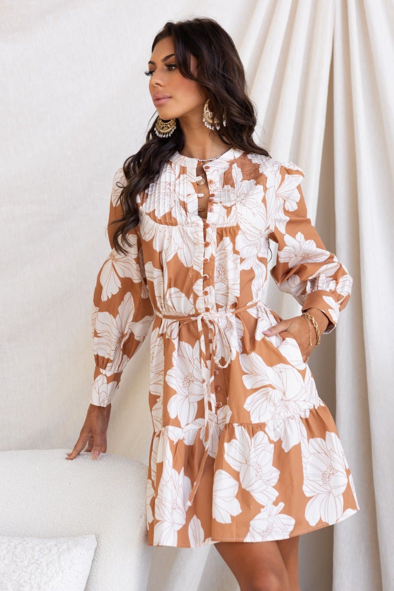 Model wearing Mellow Dress, a floral print cotton dress with button-up front, round neckline, and removable tie.