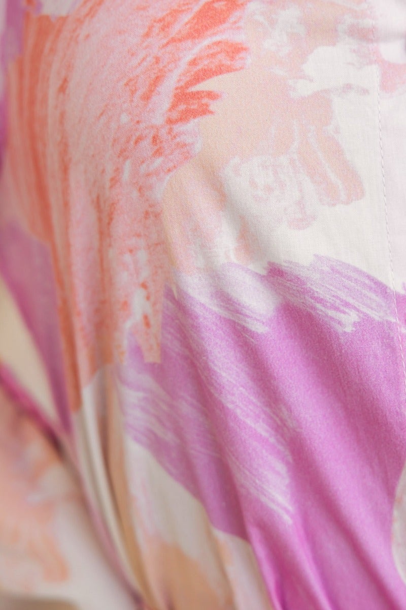 Close-up of Wrenley Dress fabric featuring vibrant pink and orange abstract patterns on soft material.