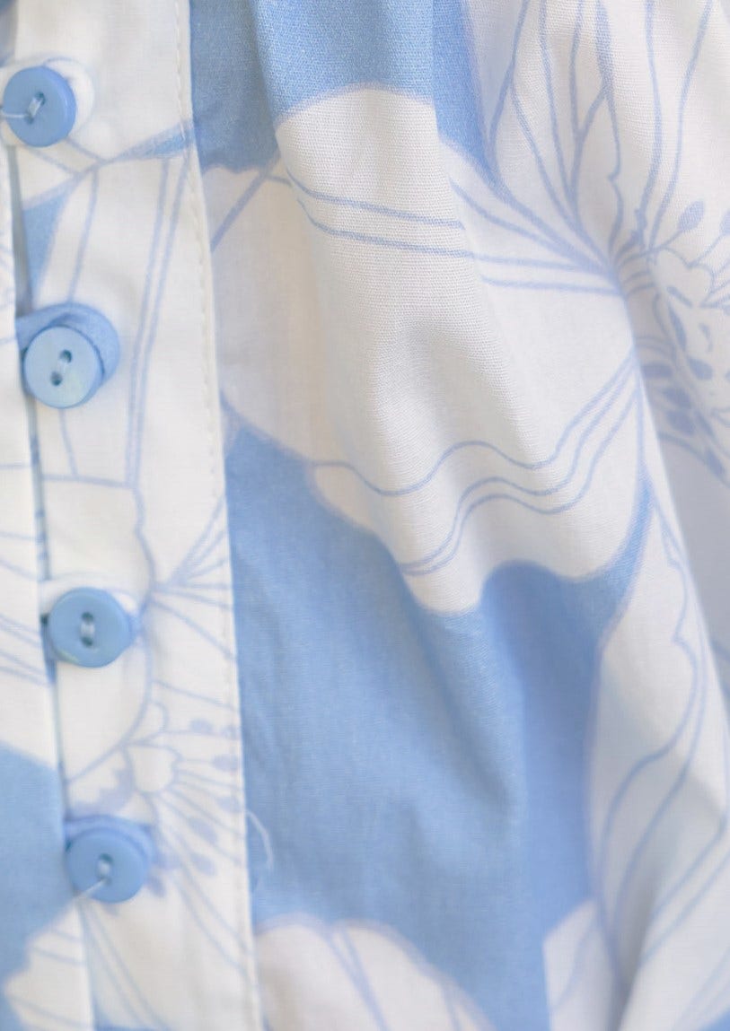 Close-up of floral print in light blue and white on Mellow Dress, featuring button details.