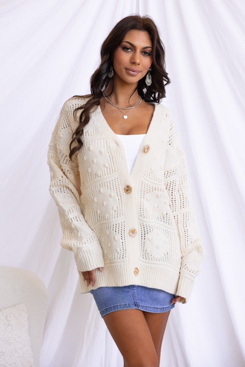 Model wearing the Azaria Cardigan, a textured knit cardigan with a V-neckline and button-up front.