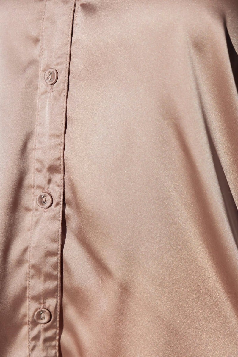Close-up of Daina Shirt, a satin button-up with a smooth finish and collar detailing in soft beige color.