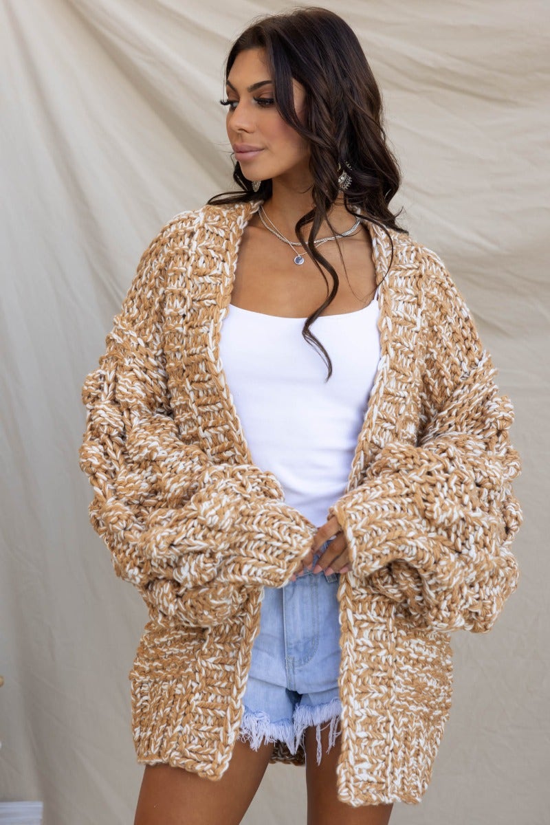 Cozy Brooklynn cardigan featuring chunky cable knit, textured sleeves, and a relaxed fit style, perfect for layering.