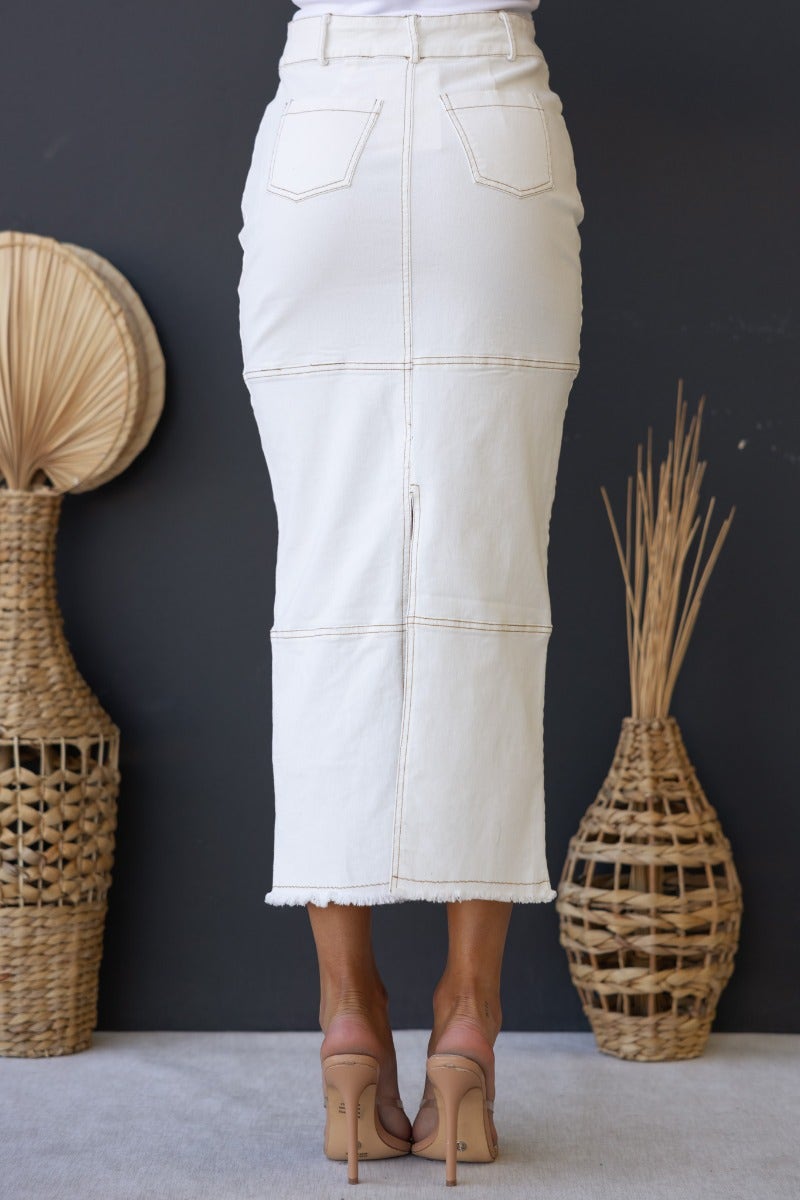 Caria Denim Midi Skirt in white, featuring a frayed hem, mid-high waist, and front & back pockets.