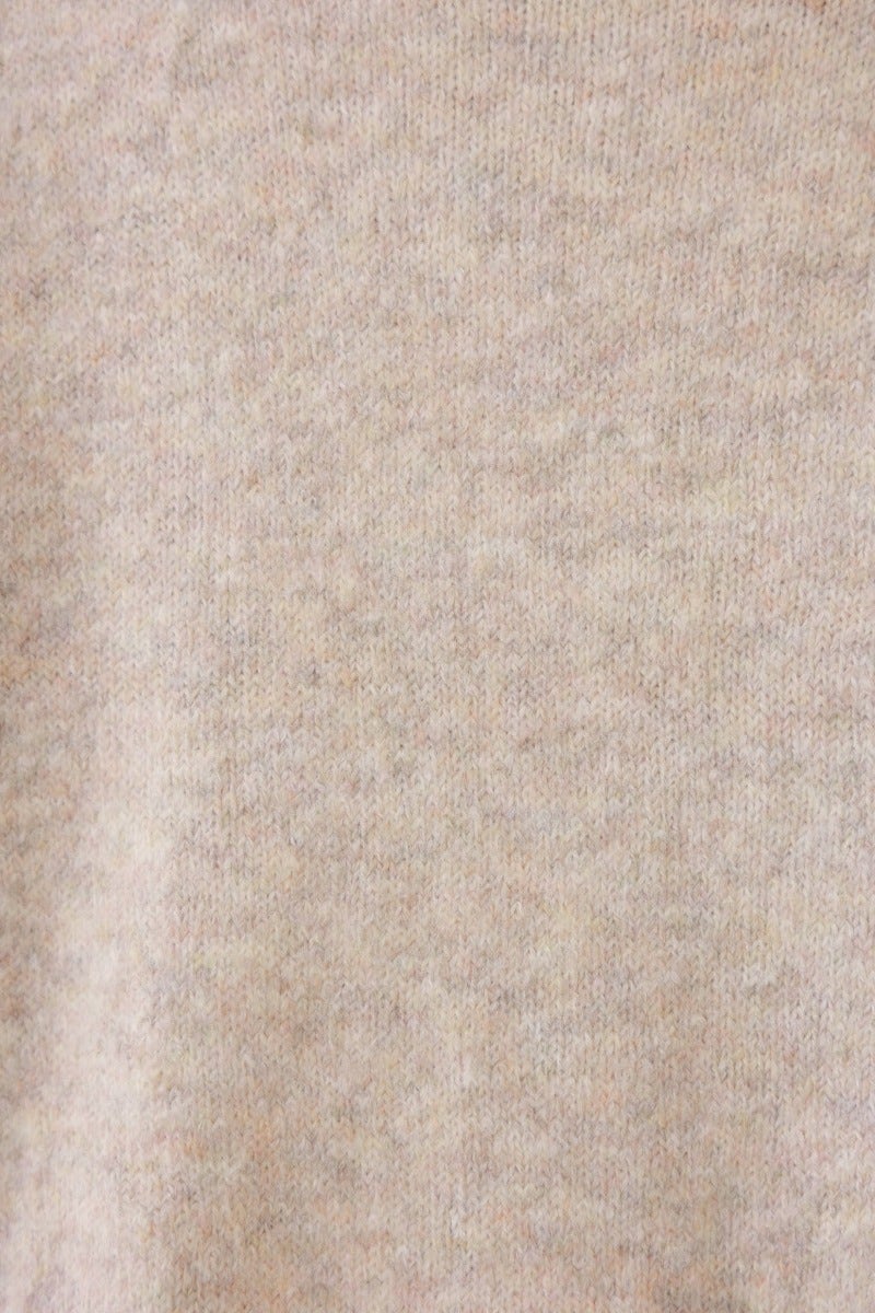 Close-up of soft, ribbed knit fabric of Orion Jumper in light beige color, showcasing a cozy texture.