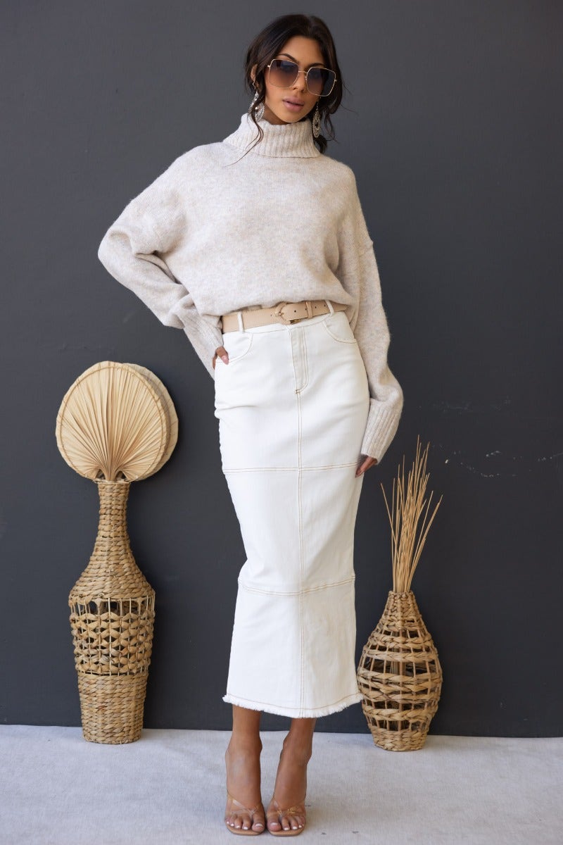 Caria Denim Midi Skirt paired with a cozy sweater and stylish sunglasses against a minimalist backdrop.