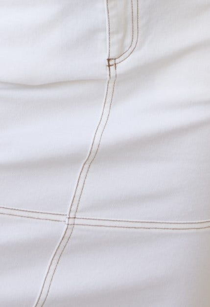 Close-up of stitching on Caria Denim Midi Skirt, showcasing the high waist fit and frayed hemline details.